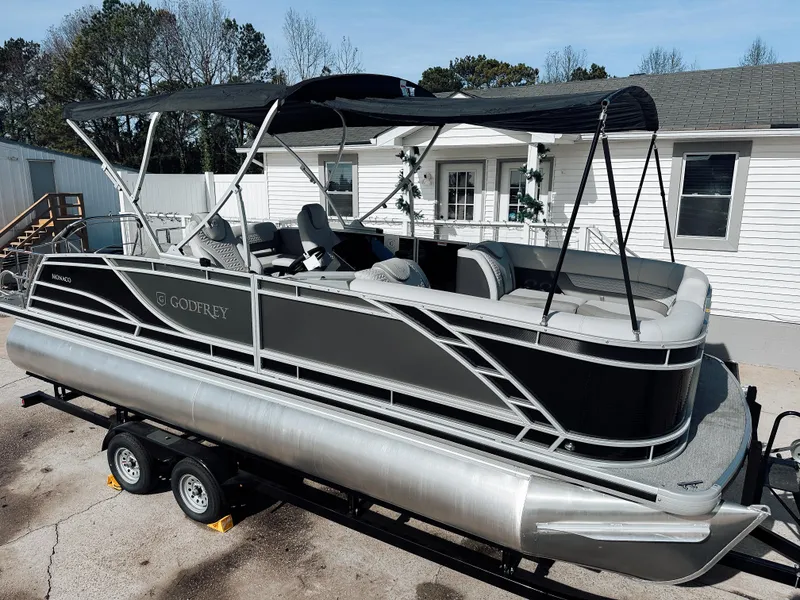 The Image of 2025 Godfrey Monaco 23' Dual Flip Lounge Tritoon with canopy on trailer. - 1
