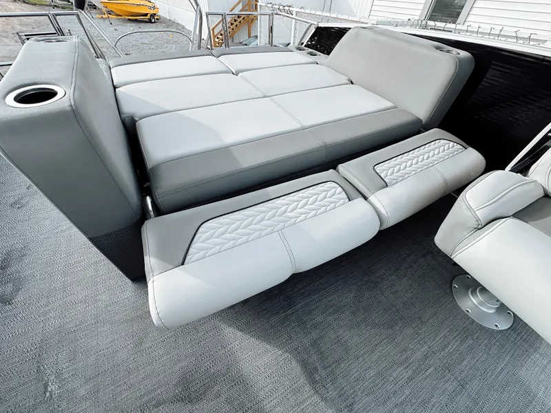 Slide: The Image of 2025 Godfrey Monaco 23' Tritoon with dual flip lounge seating, featuring elegant gray upholstery. - 6