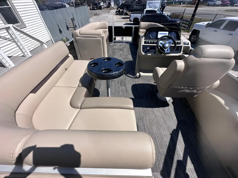 Slide: The Image of 2024 Godfrey Sweetwater 22' Tritoon interior with beige seating and steering console. - 8