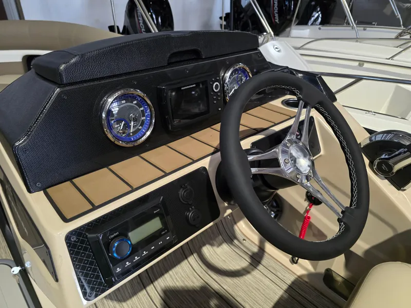 Slide: The Image of 2025 Premier 230 SunSation RF boat dashboard with steering wheel and controls. - 12