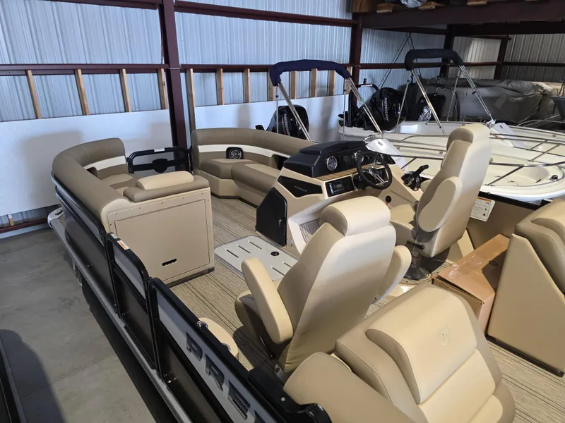Slide: The Image of 2025 Premier 230 SunSation RF pontoon boat with beige seating in storage. - 6