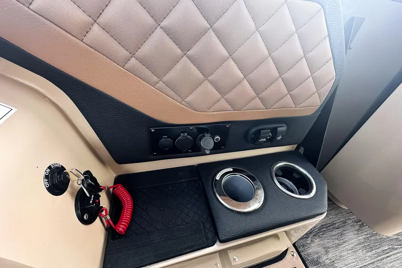 Slide: The Image of 2025 Godfrey AquaPatio 25' Tritoon dashboard with illuminated controls and steering wheel. - 10