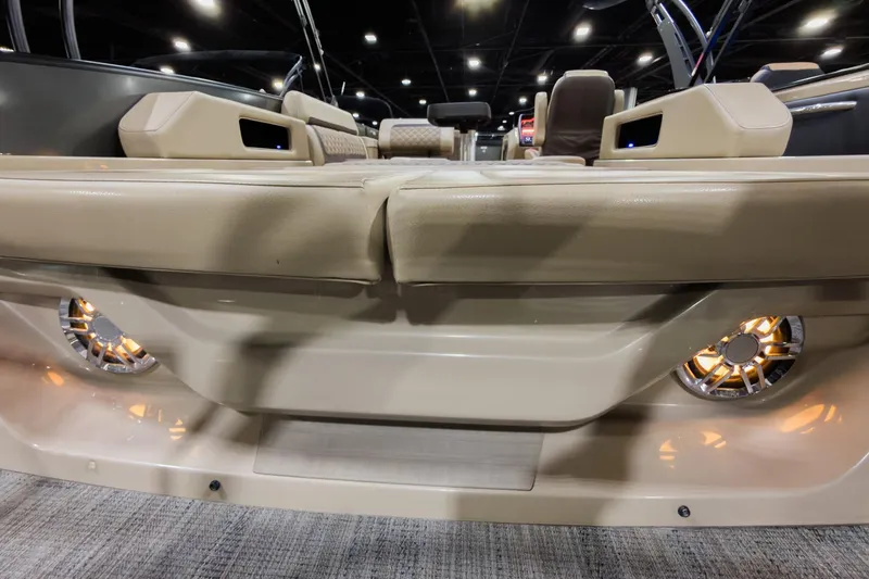Slide: The Image of 2025 Godfrey AquaPatio 25' Tritoon interior with beige seating and illuminated speakers. - 26