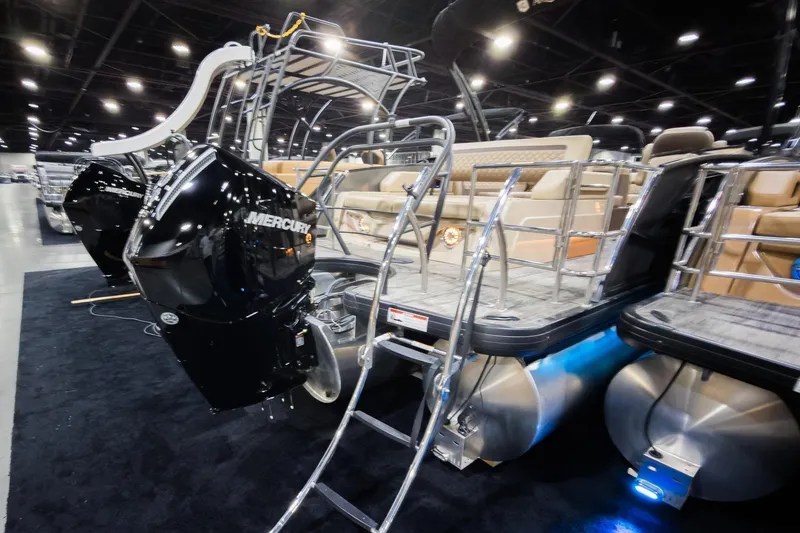 Slide: The Image of 2025 Godfrey AquaPatio 25' Tritoon with Mercury engine, showcased indoors. - 29