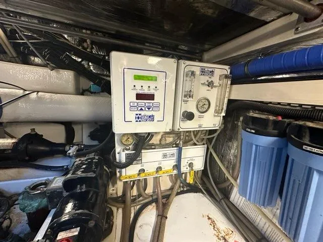 Slide: The Image of Engine room of 1996 Tiara Yachts 43 Open with control panels and filters. - 38