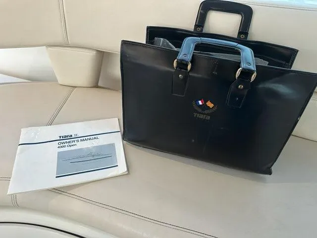 Slide: The Image of Tiara Yachts 43 Open 1996 owner's manual and black leather bag on boat seat. - 47