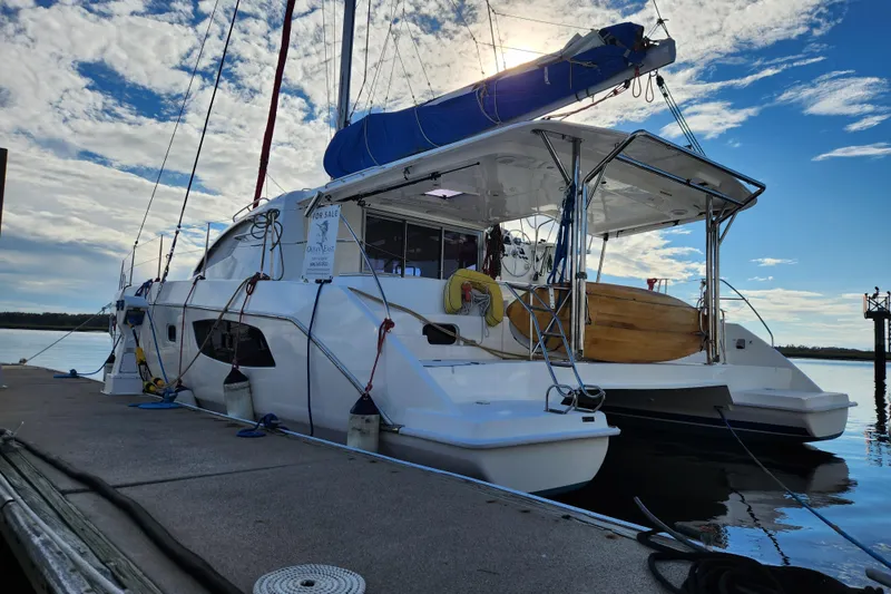 The Image of 2015 Leopard 44 catamaran docked, featuring a spacious deck and blue sail cover. - 0