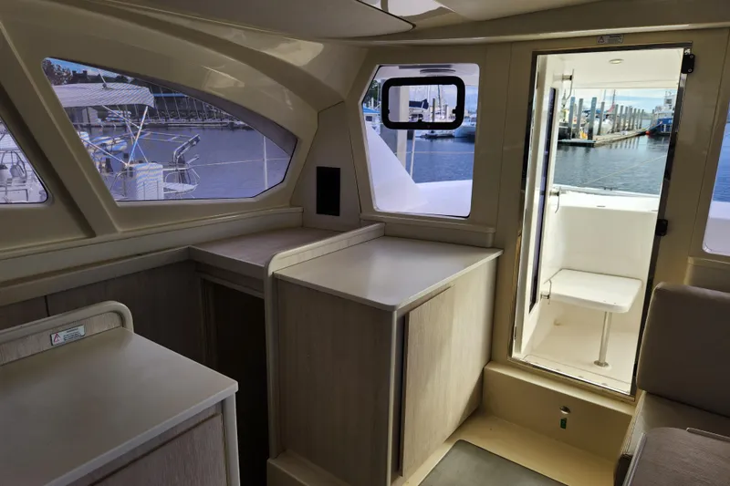 Slide: The Image of Interior of 2015 Leopard 44 catamaran with marina view through windows and open door. - 133