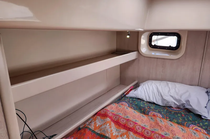 Slide: The Image of Cozy cabin interior of 2015 Leopard 44 yacht with colorful bedding and small window. - 140