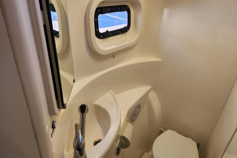 Slide: The Image of Compact bathroom in a 2015 Leopard 44 yacht with sink, toilet, and porthole window. - 158