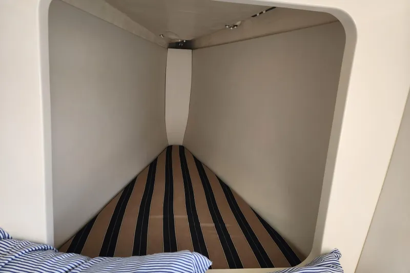 Slide: The Image of Cozy cabin interior of 2015 Leopard 44 yacht with striped bedding. - 165
