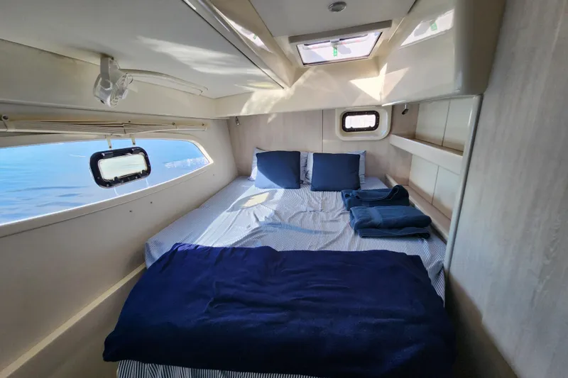 Slide: The Image of Cozy cabin interior of 2015 Leopard 44 yacht with bed and windows. - 180