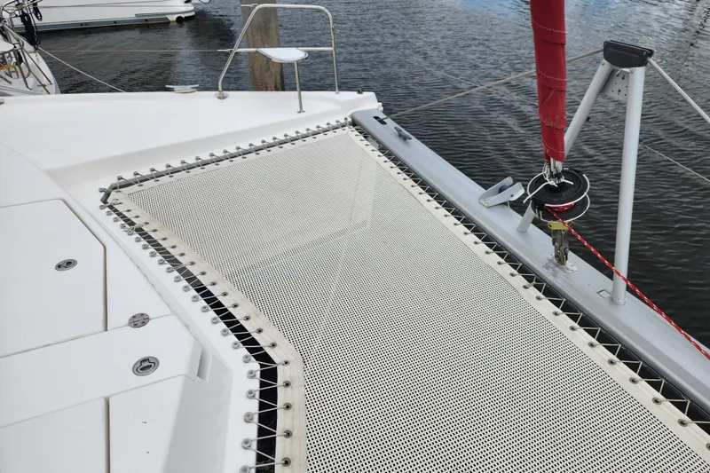 Slide: The Image of 2015 Leopard 44 catamaran with netting and rigging details, docked on calm water. - 59
