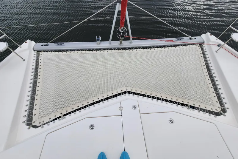 Slide: The Image of Front deck of a 2015 Leopard 44 catamaran with netting over water. - 61