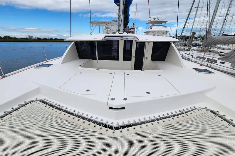 Slide: The Image of 2015 Leopard 44 catamaran deck with netting, docked at marina under blue sky. - 62