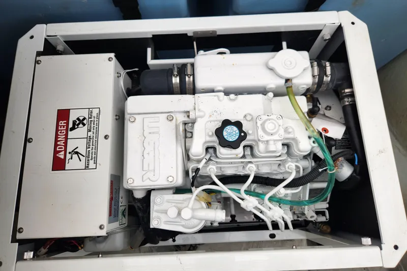 Slide: The Image of Engine compartment of a 2015 Leopard 44, featuring mechanical components and warning labels. - 64