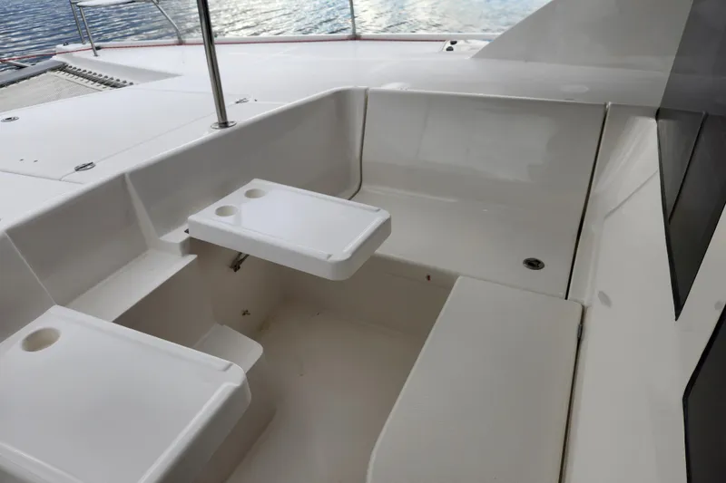 Slide: The Image of 2015 Leopard 44 catamaran cockpit with white seating and table, overlooking water. - 74