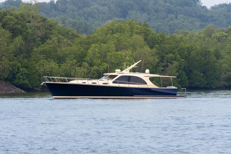 Slide: The Image of 2026 Palm Beach Motor Yachts PB52 cruising on a serene lake with lush green forest backdrop. - 22