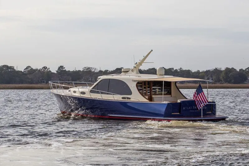 Slide: The Image of 2026 Palm Beach Motor Yachts PB52 cruising on a calm river. - 23