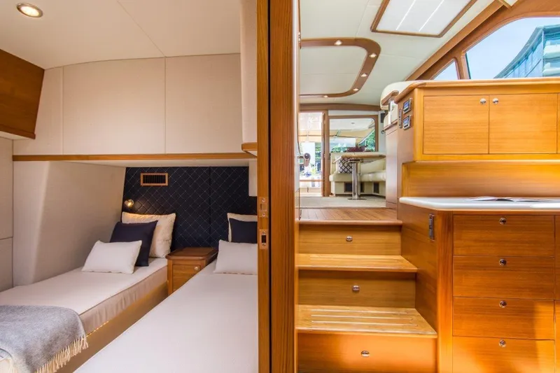 Slide: The Image of Luxurious interior of 2026 Palm Beach Motor Yachts PB52, featuring elegant wood finishes and cozy bedding. - 5