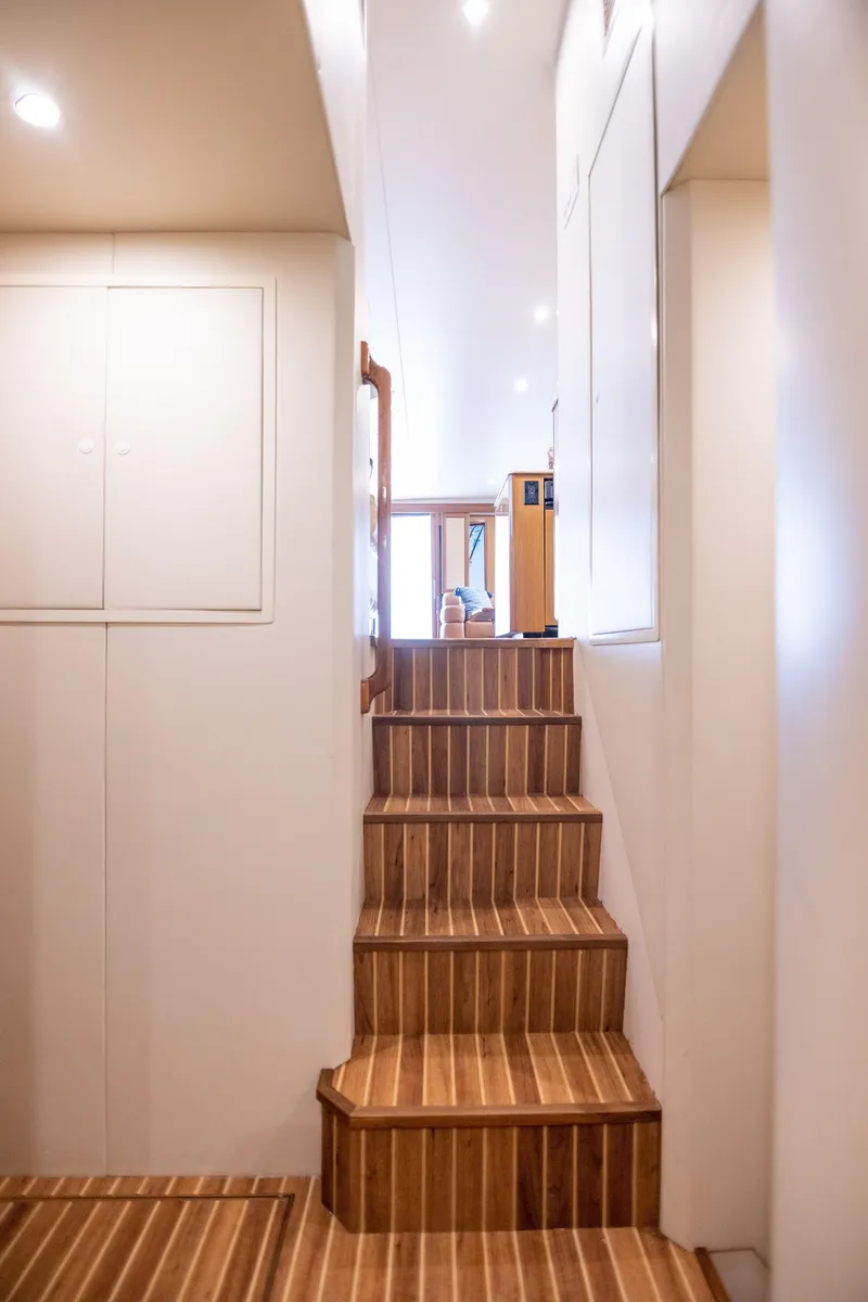 Slide: The Image of Interior staircase of 2003 Viking 65 Convertible Enclosed Bridge yacht, featuring wooden steps. - 17