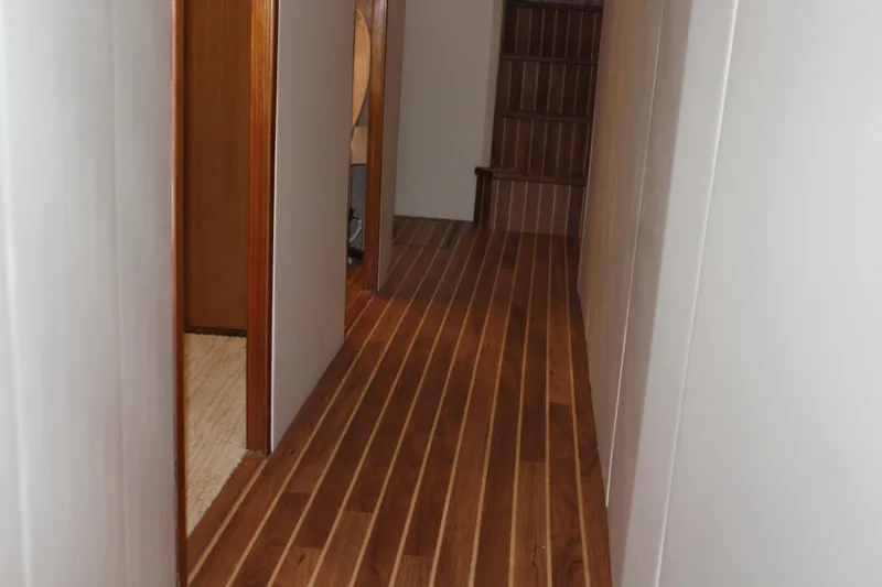 Slide: The Image of Hallway inside 2003 Viking 65 Convertible Enclosed Bridge with wooden flooring and open doorways. - 18