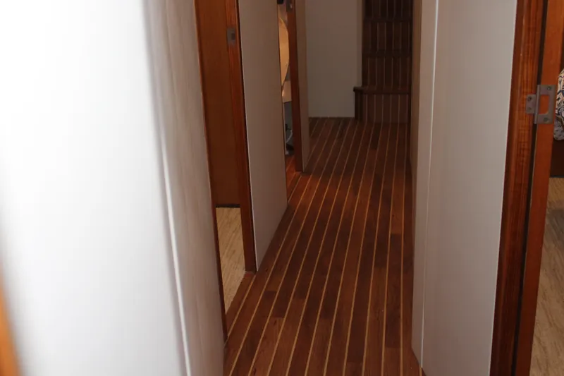 Slide: The Image of Hallway with wooden flooring on a 2003 Viking 65 Convertible Enclosed Bridge yacht. - 19