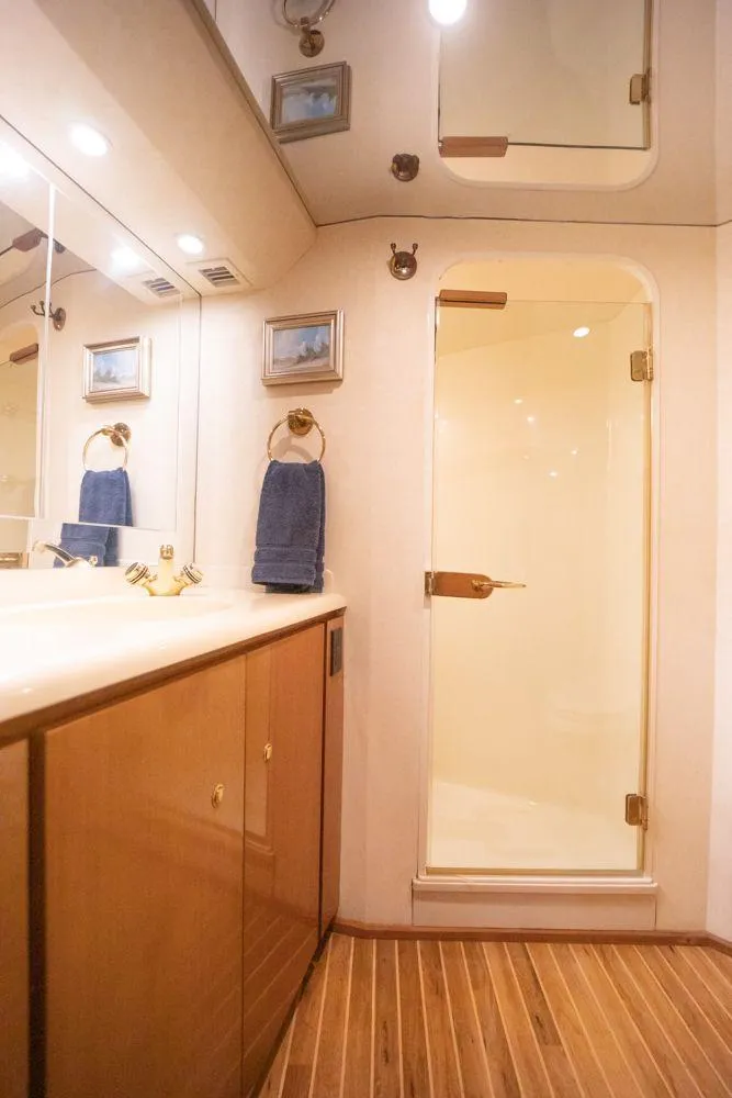 Slide: The Image of Bathroom interior of 2003 Viking 65 Convertible Enclosed Bridge yacht with wooden cabinetry and shower. - 32