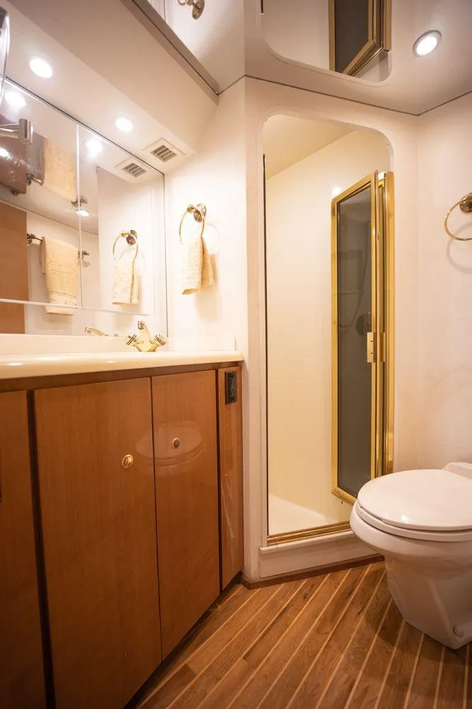 Slide: The Image of Luxurious bathroom in 2003 Viking 65 Convertible Enclosed Bridge yacht with wood accents. - 33