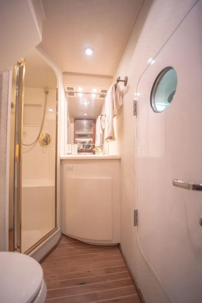 Slide: The Image of Bathroom interior of 2003 Viking 65 Convertible Enclosed Bridge yacht, featuring shower and porthole. - 35