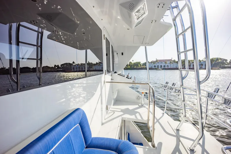 Slide: The Image of 2003 Viking 65 Convertible Enclosed Bridge yacht with blue seating, docked by waterfront homes. - 46