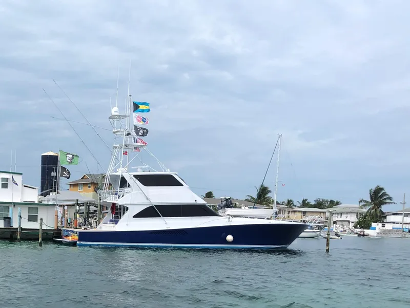 Slide: The Image of 2003 Viking 65 Convertible Enclosed Bridge yacht docked near coastal buildings. - 5