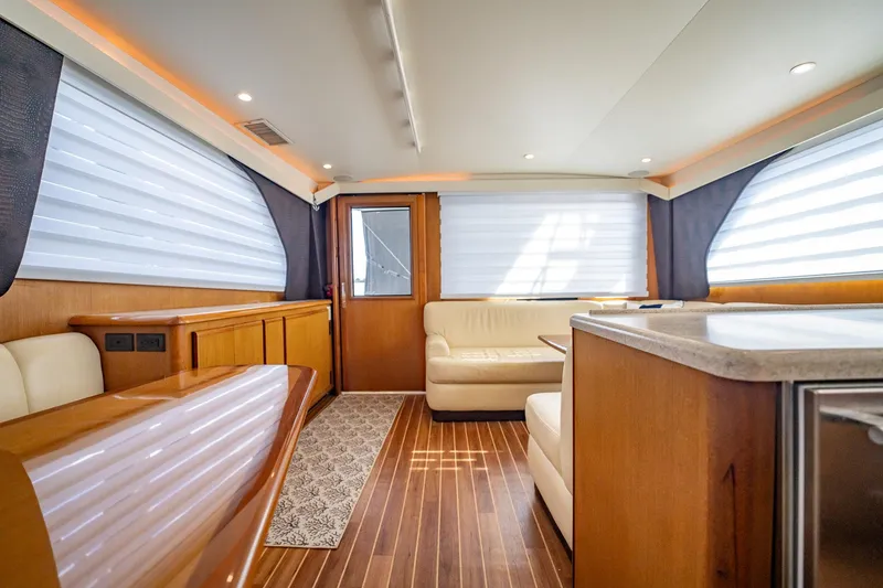 Slide: The Image of Luxurious interior of 2000 Viking 50 Conv Sport Fisher yacht with wood flooring and plush seating. - 21