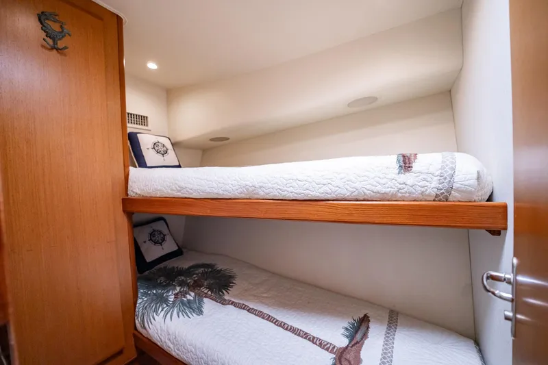 Slide: The Image of Bunk beds in 2000 Viking 50 Conv Sport Fisher cabin, featuring nautical-themed bedding. - 33