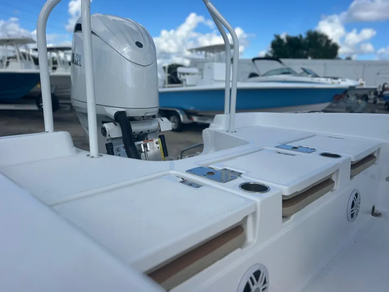 Slide: The Image of 2025 NauticStar 231 Hybrid boat with motor, docked under a clear blue sky. - 5