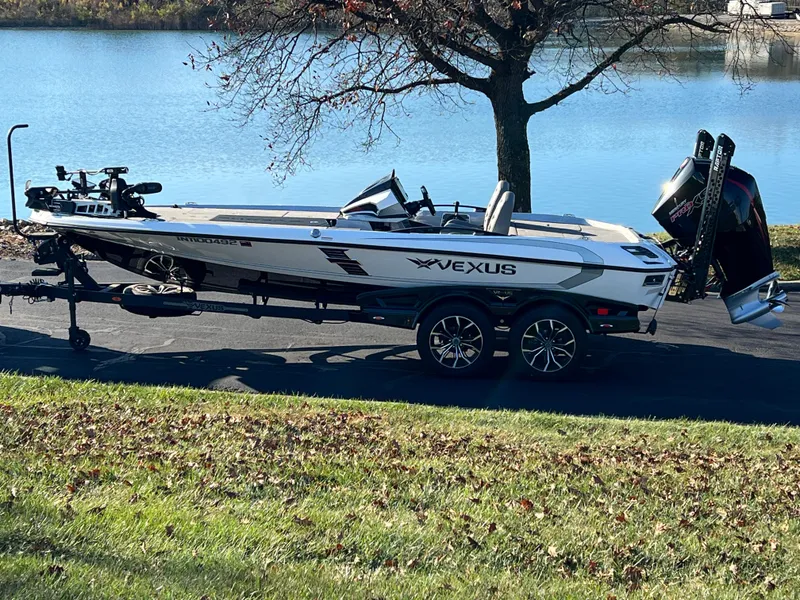 Slide: The Image of 2024 Vexus VXS20 boat on trailer by a lake, showcasing sleek design and modern features. - 2
