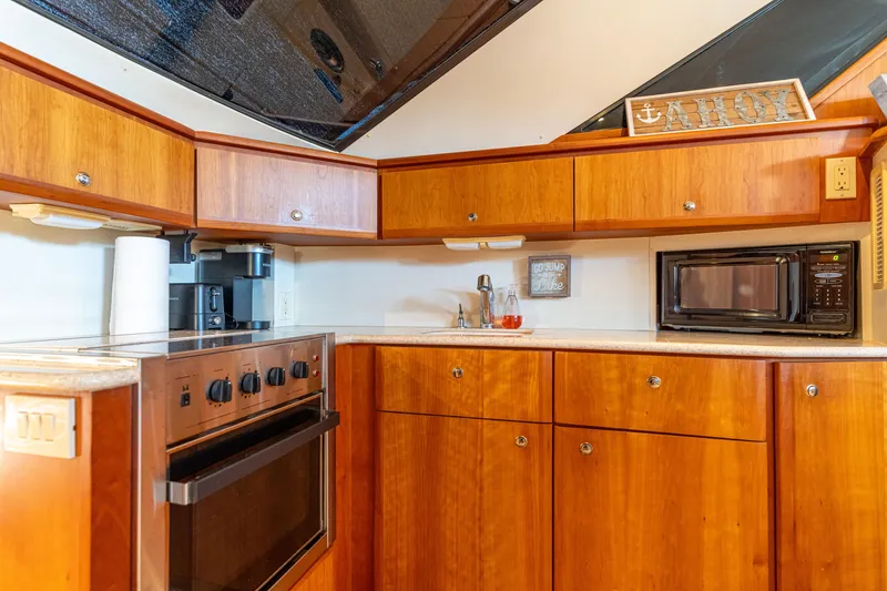 Slide: The Image of 2001 Silverton 392 Motor Yacht kitchen with wood cabinets, stove, and microwave. - 24