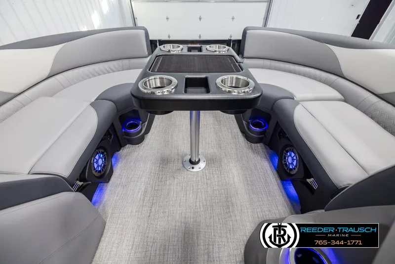Slide: The Image of 2025 Avalon LSZ QLS boat interior with gray seating, cup holders, and blue LED lighting. - 20