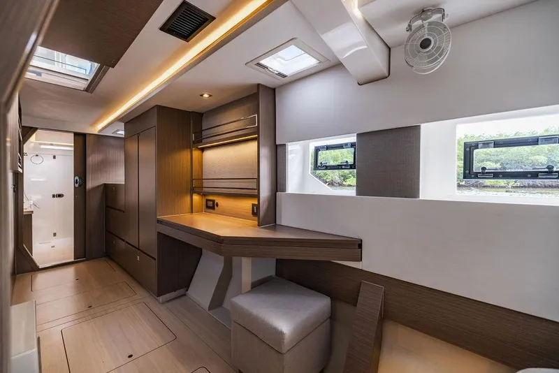 Slide: The Image of 2024 Leopard 45 yacht interior with modern design, featuring a desk, seating, and ample natural light. - 8