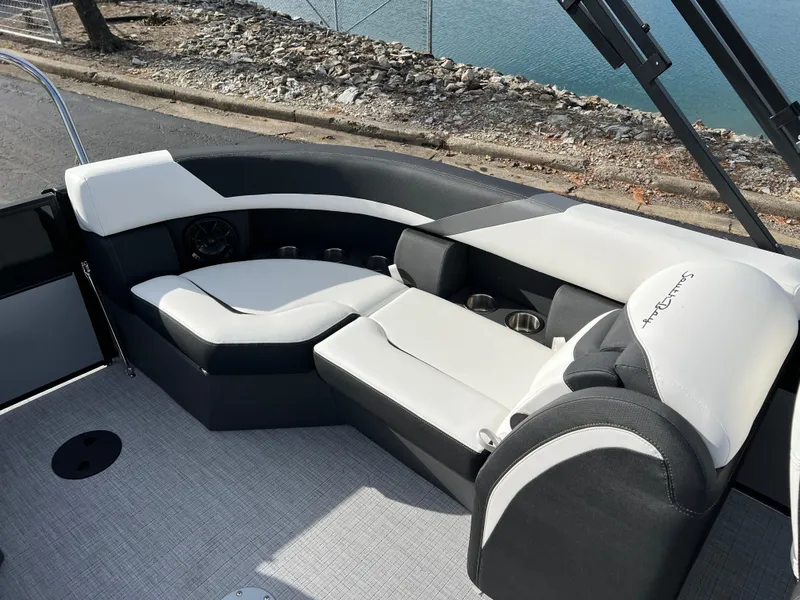 Slide: The Image of 2025 South Bay 222RS boat interior with sleek black and white seating by the water. - 14