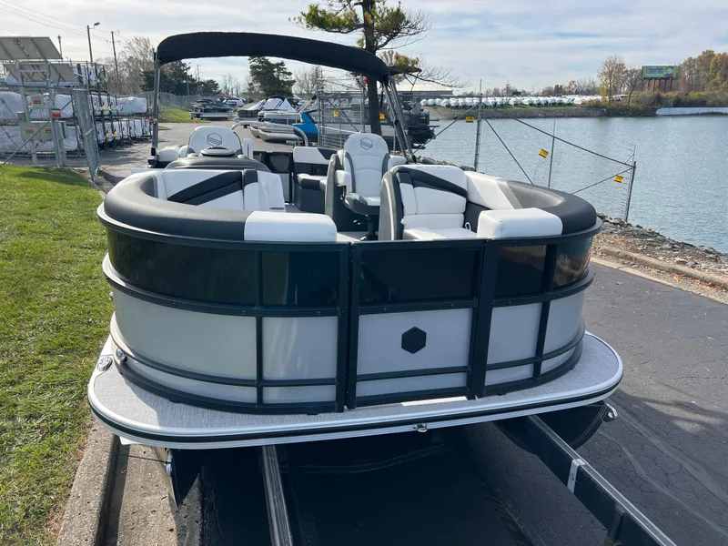 Slide: The Image of 2025 South Bay 222RS pontoon boat docked by a lakeside. - 2