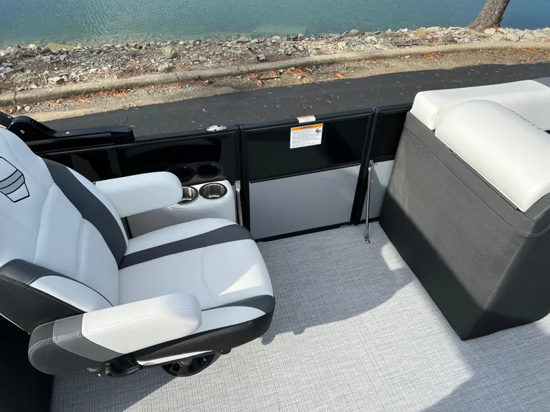 Slide: The Image of 2025 South Bay 222RS boat interior with white and gray seating by the water. - 20