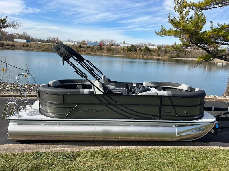 Slide: The Image of 2025 South Bay 220RS pontoon boat by a serene lake. - 1