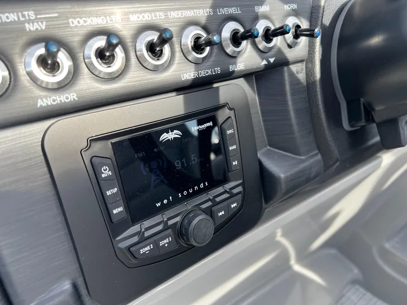 Slide: The Image of 2025 South Bay 220RS boat dashboard with Wet Sounds audio system and control switches. - 19