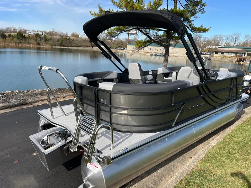 Slide: The Image of 2025 South Bay 220RS pontoon boat docked by a serene lake. - 4
