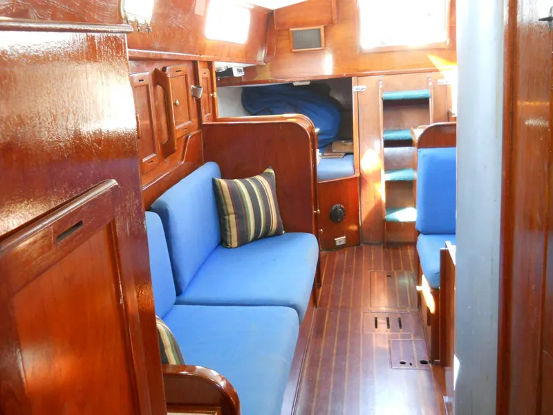 The Image of 1979 Morgan 382 yacht interior with blue seating, wooden finish, and striped cushions. - 1