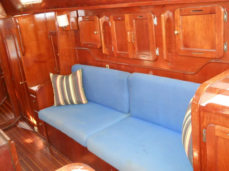 Slide: The Image of 1979 Morgan 382 yacht interior with blue sofa and wooden cabinetry. - 14