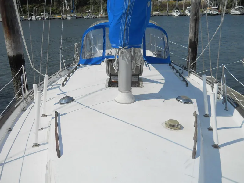 Slide: The Image of 1979 Morgan 382 sailboat deck with blue sail cover, docked in a marina. - 18