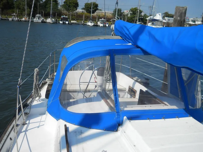 Slide: The Image of 1979 Morgan 382 sailboat with blue canopy docked in a marina. - 19