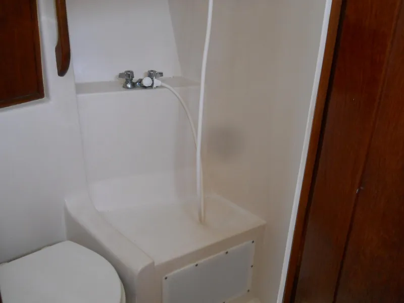 Slide: The Image of 1979 Morgan 382 yacht bathroom with shower and toilet, featuring wooden accents. - 6